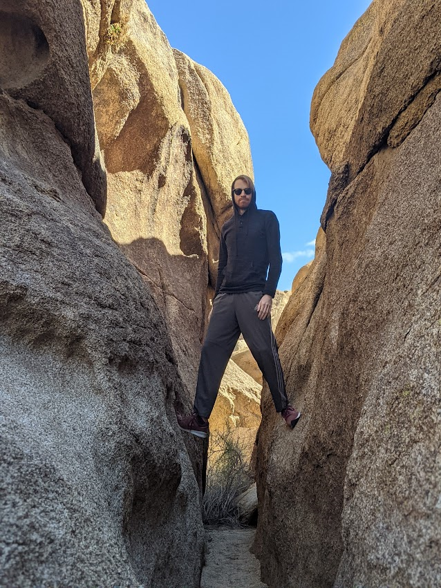 A guy standing in between two rocks